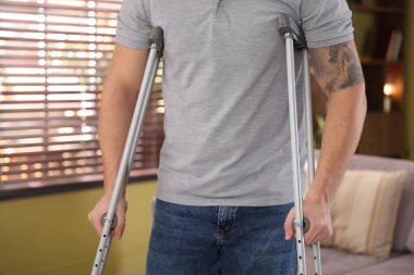 Evde koltuk değneği kullanan bir adam, yakın plan.