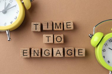 Pastel kahverengi zemin üzerinde harf ve alarm saatleri ile ahşap küplerden yapılmış metin zamanı, üst görünüm