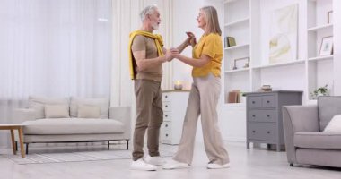 Güzel yaşlı çift evde dans ediyor.