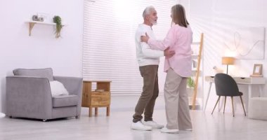 Güzel yaşlı çift evde dans ediyor.