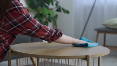 Ahşap masadaki tozları silen kadın, yakın plan.