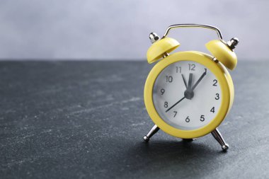 Siyah masadaki çalar saat, yakın plan. Metin için boşluk