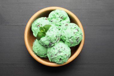 Nefis naneli çikolatalı dondurma kasede, siyah ahşap masada, üst tarafta.