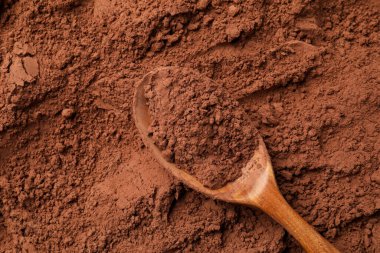 Kakao tozu ve tahta kaşık arka plan olarak, üst görünüm