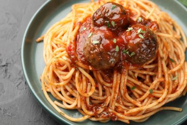 Köfteli lezzetli makarna, siyah desenli masa, yakın plan.