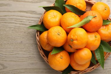 Taze mandalinalar ve ahşap masa üzerinde yeşil yapraklar, üst manzara. Metin için boşluk