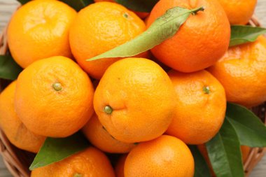 Taze mandalina ve yeşil yapraklar masada, yakın plan.