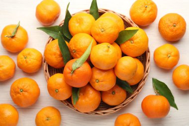 Taze mandalina ve yeşil yapraklar beyaz ahşap masada, düz yatıyordu.