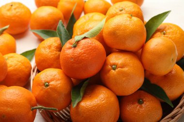 Taze mandalina ve yeşil yapraklar masada, yakın plan.