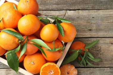 Taze mandalina ve yeşil yapraklar ahşap masa üzerinde, üst manzara. Metin için boşluk