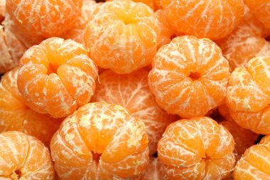 Arka plan olarak birçok olgun soyulmuş mandalina, üst görünüm