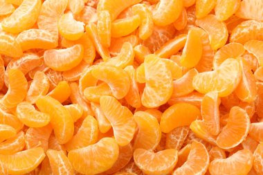 Arka plan olarak birçok olgun soyulmuş mandalina, üst görünüm