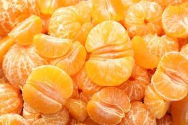 Arka plan olarak birçok olgun soyulmuş mandalina, üst görünüm