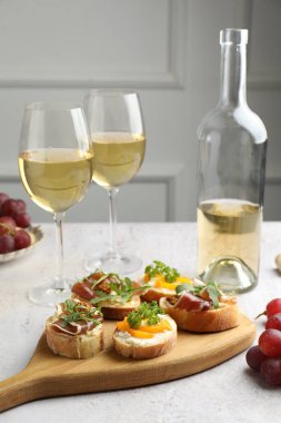 Beyaz masada servis edilen prosciutto ve şaraplı lezzetli bruschettalar.