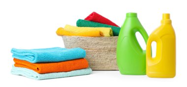 Çamaşır sepeti, havlular ve beyaza izole edilmiş deterjan şişeleri.