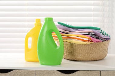 Çamaşır sepetinin içinde çamaşır ve şişe deterjan vardı.