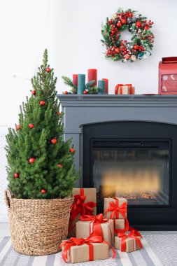 İçinde Noel dekoru ve şöminesi olan küçük ladin ağacı.