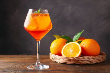 Bir bardak ferahlatıcı spritzer kokteyli. Nane ve portakallar ahşap masada.