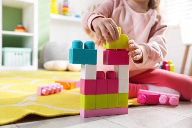 Küçük kız oyuncaklarla oynuyor oyun odasında, yakın plan.