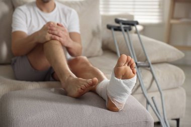 Koltukta koltuk değnekleriyle oturan, seçici odaklı bir adam.