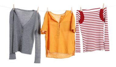 Çamaşır ipini beyaz arka planda tutarken farklı giysiler kuruyor