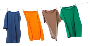 Çamaşır ipini beyaz arka planda tutarken farklı giysiler kuruyor