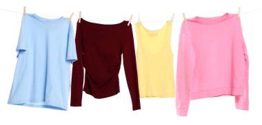 Çamaşır ipini beyaz arka planda tutarken farklı giysiler kuruyor