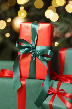 Kapalı alanda Noel ağacının altında bir sürü hediye kutusu var.