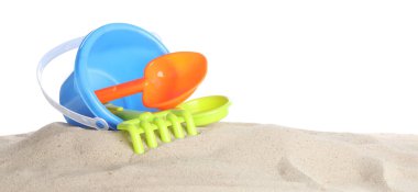 Çocuklar için plaj oyuncakları ve beyaz pankartta izole edilmiş kum. Plastik kova, kürek, tırmık ve süzgeç.