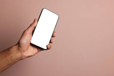 Dusty Rose arka planında boş ekranlı akıllı telefon tutan adam, yakın plan. Tasarım için model