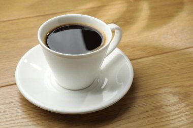 Ahşap masada, fincanda Aromatik kahve, yakın plan.