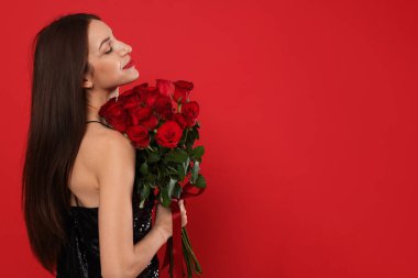 Sevgililer Günü. Kırmızı arka planda gül buketi olan güzel bir kadın. Metin için boşluk
