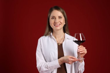 Kırmızı arka planda şarap kadehi olan profesyonel şarap garsonu.