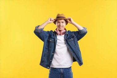 Sarı arka planda kablosuz kulaklıklı adam.