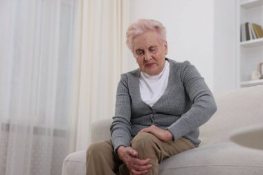 Evde diz ağrısı çeken yaşlı bir kadın, mesaj için yer var. Romatizma belirtileri