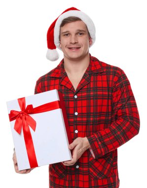 Noel Baba şapkalı ve pijamalı mutlu bir adam.