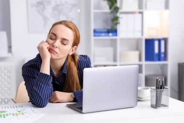 Ofiste uyuyan yorgun bir kadın.