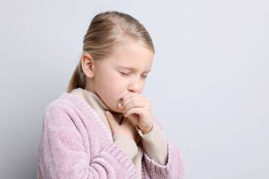 Küçük kız arka planda öksürüyor, mesaj için yer var. Soğuk Semptom
