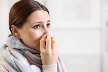 Evde burnu akan bir kadın, yakın çekim ve mesaj için yer. Soğuk Semptom