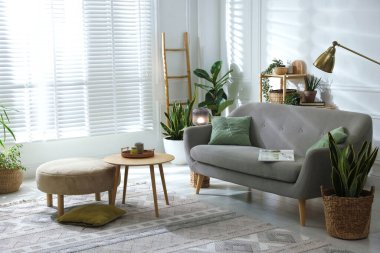 Kanepesi ve çiçekleri olan şık bir oturma odası. İç tasarım