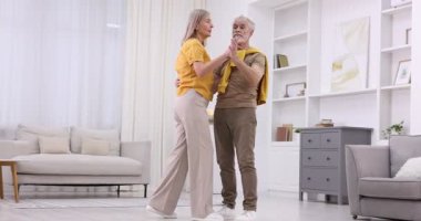Güzel yaşlı çift evde dans ediyor.
