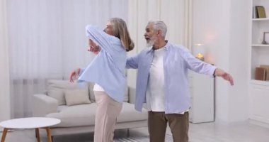 Güzel yaşlı çift evde dans ediyor.