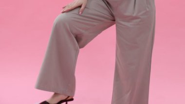 Şişme topları olan bir ofis çalışanı pembe arka planda telefonla konuşuyor. Kamera yukarı hareket ediyor