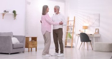 Güzel yaşlı çift evde dans ediyor.