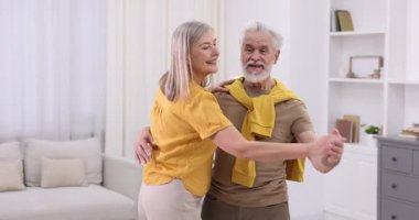 Güzel yaşlı çift evde dans ediyor.