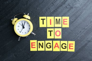 Siyah masadaki çalar saati çalıştırmak ve alarma geçirmek için metin zamanı olan kartlar, düz yatıyordu