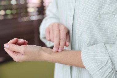 Kadın nabzını evde kontrol ediyor, yakın plan.