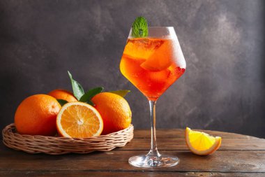 Bir bardak ferahlatıcı spritzer kokteyli. Nane ve portakallar ahşap masada.