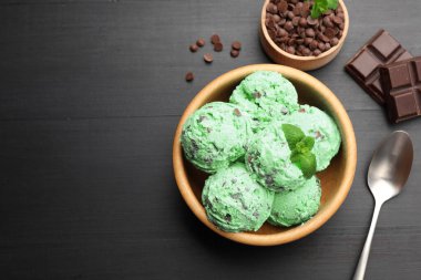 Siyah ahşap masada servis edilen naneli çikolatalı dondurma. Metin için boşluk