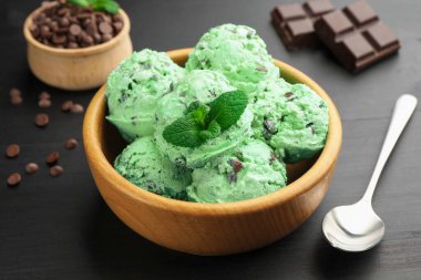 Siyah ahşap masada servis edilen naneli çikolatalı dondurma.